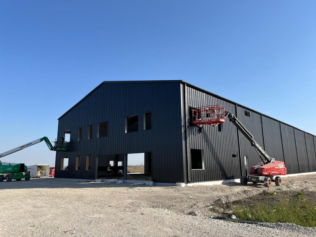 Black pre-engineered steel warehouse under construction
