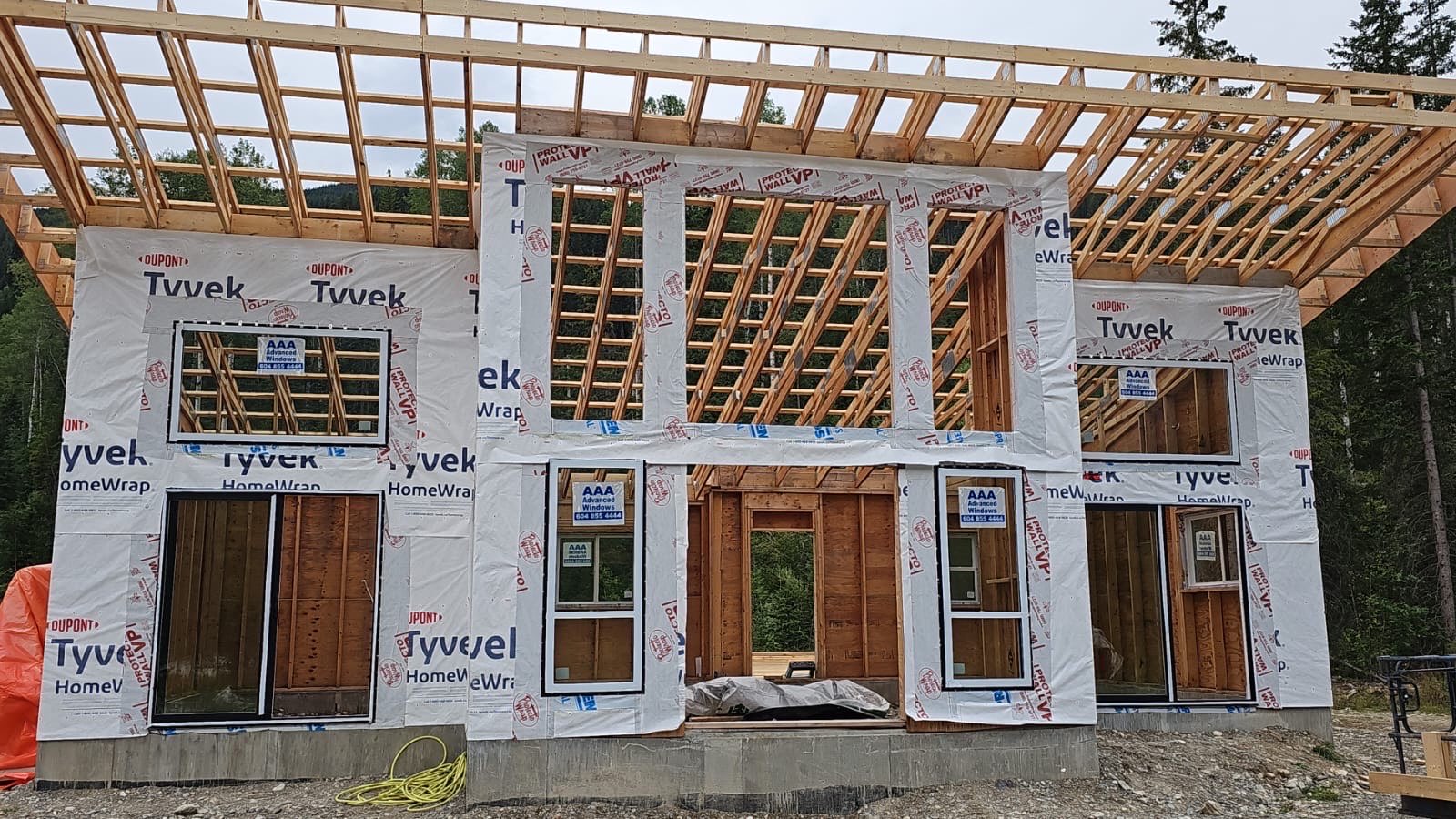 Two-storey cabin framed and wrapped in house wrap in summer