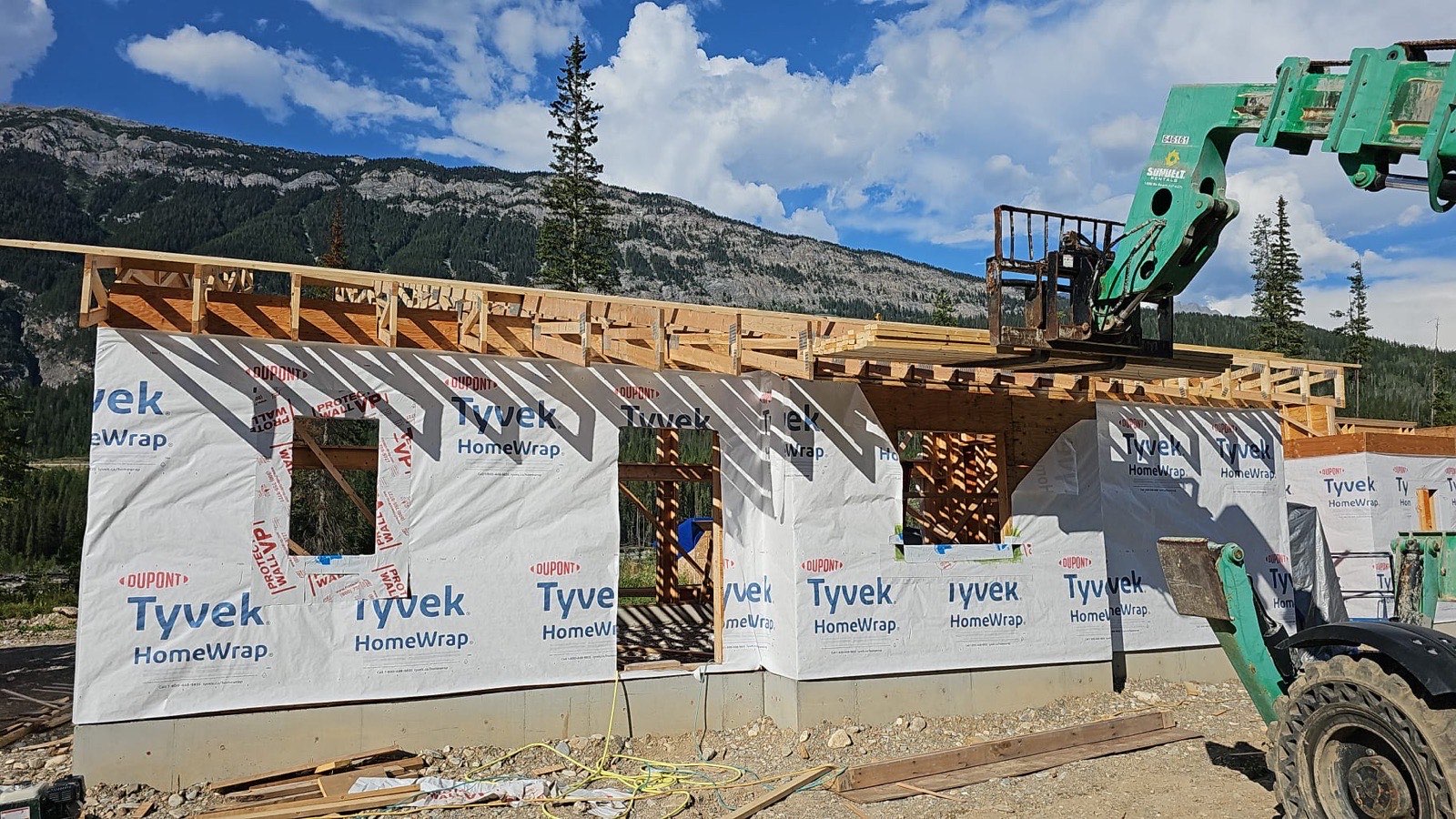 Single-storey cabin framed with house wrap in summer